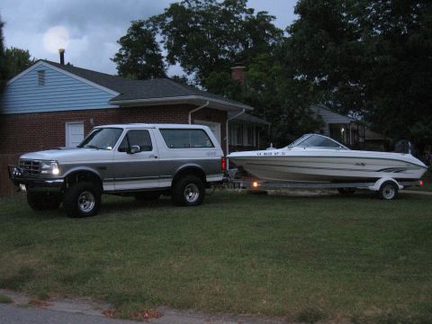 1994 Ford Bronco - A 1994 Ford Bronco is seen towing a boat on a trailer in front of a house.