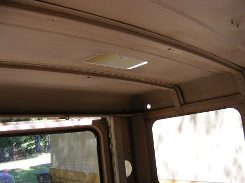 Interior view of vehicle headliner with skylight and window frame