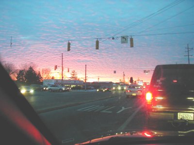1997 Ford Taurus - A traffic scene unfolds under a colorful sunset sky, with several vehicles visible on the road.