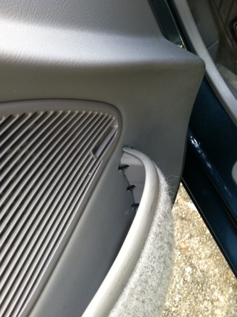 1997 Ford Probe - Close-up of a car's interior door panel, focusing on the speaker grille and pull handle.