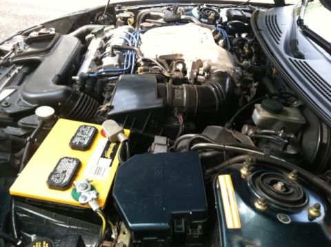 1997 Ford Probe - The engine bay of a 1997 Ford Probe shows the battery, fuse box, and engine components.