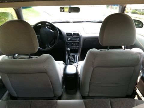 1997 Ford Probe - The interior of a car is shown from the back seat, looking towards the front dashboard and controls.