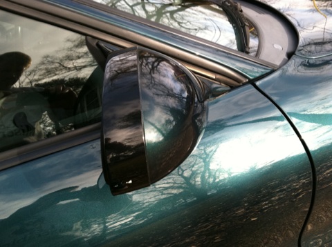 1997 Ford Probe - Side mirror and door panel of a car with reflections of the surrounding environment.
