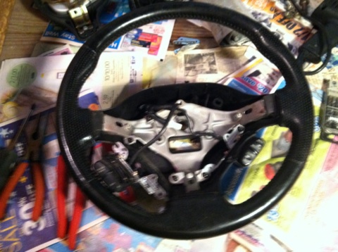 1997 Ford Probe - A steering wheel is shown with its internal components exposed, placed on a surface covered with various papers.
