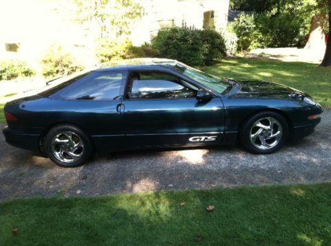 1997 Ford Probe - Side view of a dark green 1997 Ford Probe GTS with chrome wheels.