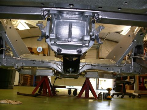 1976 Chevrolet Corvette - The underside of a vehicle is shown, supported by jack stands, with the differential and frame components visible.