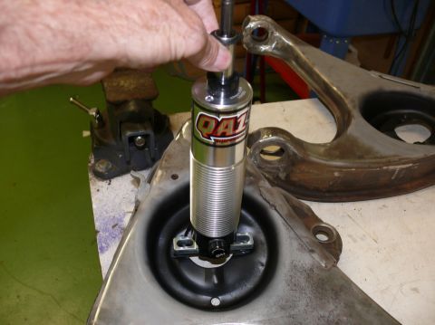 1976 Chevrolet Corvette - A QA1 shock absorber is being installed onto a vehicle's suspension component, likely during a repair or upgrade.