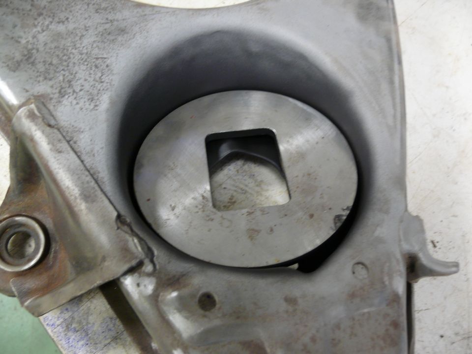 close-up of a metal component with a circular opening and a square hole in the center