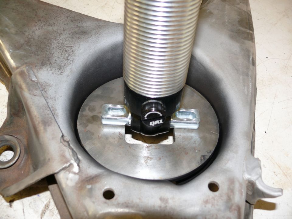 Shock absorber assembly with QA1 branding, attached to a metal suspension component