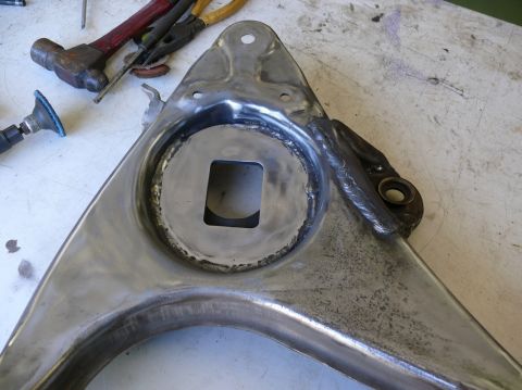 1976 Chevrolet Corvette - A suspension control arm is shown after welding work, with tools in the background.