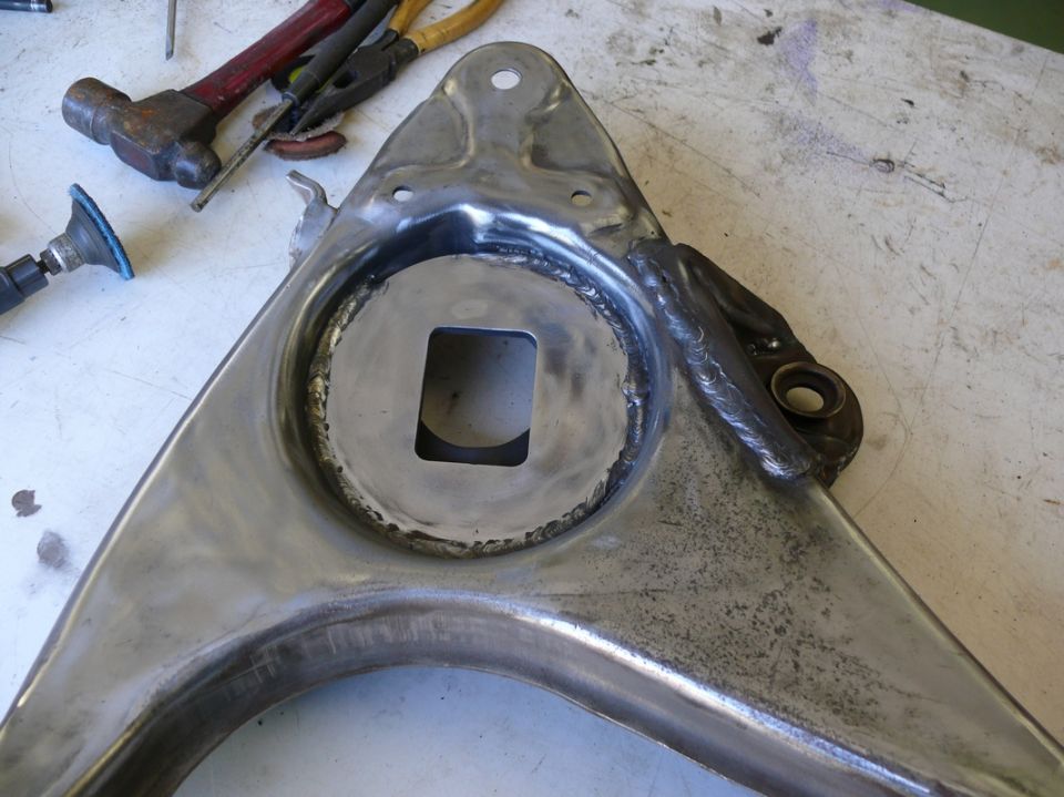 Welded suspension control arm with a square cutout in the center