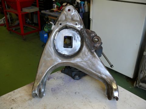 1976 Chevrolet Corvette - A metal car suspension control arm is shown, possibly undergoing restoration or modification.