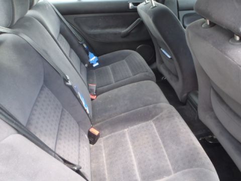 2002 Volkswagen Jetta - The rear interior of a car, showing the seats and seatbelts, with a blue air freshener attached.