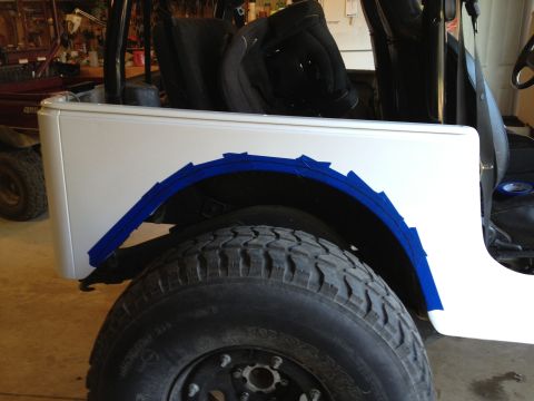 2000 Jeep TJ - Blue tape marks the area to be cut on a white Jeep fender, likely for larger tires.