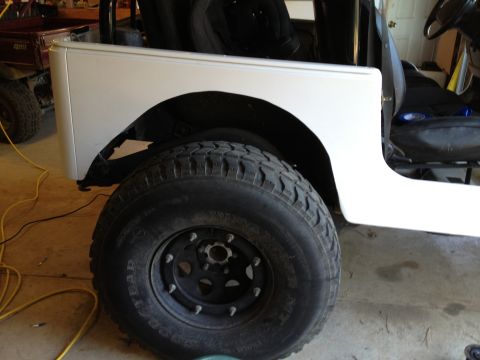 2000 Jeep TJ - Side view of a white Jeep TJ showing the rear fender and tire, with interior seats visible.
