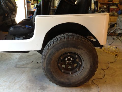 2000 Jeep TJ - The rear wheel well and tire of a Jeep are visible, with the interior and part of the body in the background.