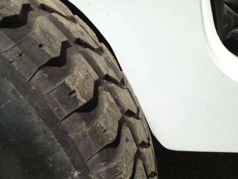 2000 Jeep TJ - A large off-road tire is shown fitted to a vehicle with a white fender.