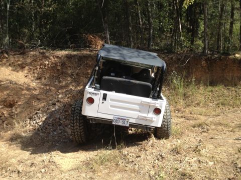 2000 Jeep TJ - White Jeep TJ navigates a steep dirt path in a wooded area.