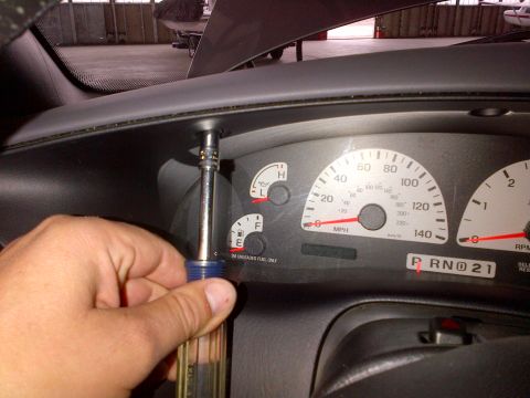 2003 Ford F-150 - A hand is shown removing a screw from the dashboard of a 2003 Ford F-150 Lightning.