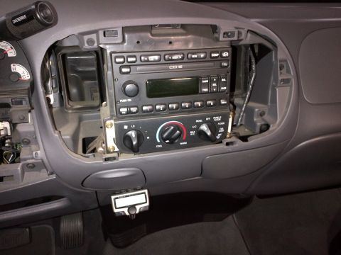 2003 Ford F-150 - The dashboard of a 2003 Ford F-150 shows the radio and climate control area with components disassembled.