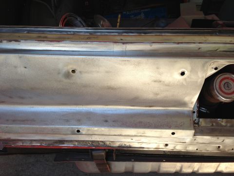 1964 Ford Fairlane - Bare metal interior door panel with holes drilled, showing part of a fuel cap.