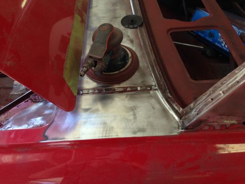 1964 Ford Fairlane - A pneumatic sander sits on a freshly metal-worked section of a car's body, ready for the next step in repair.
