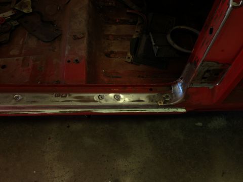 1964 Ford Fairlane - Interior view of a car's floor pan and door sill, showing rust and metal trim with some text.