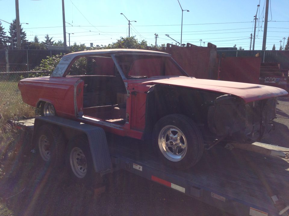Red 1964 Ford Fairlane coupe body on a trailer, missing doors and front clip