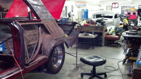 1964 Ford Fairlane - A car in a workshop is being restored, with another vehicle visible in the background.