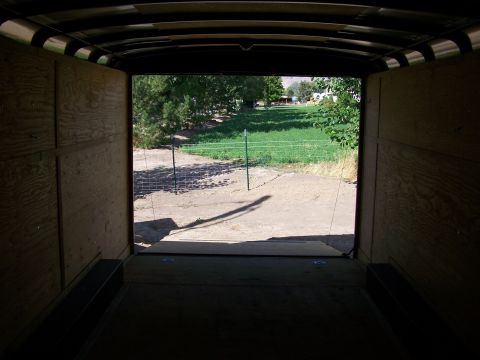 1988 Suzuki Samurai - View from inside a trailer shows the exterior landscape with trees and a grassy area.