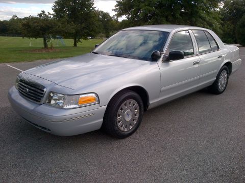 2001 Ford Crown Victoria - A silver 2001 Ford Crown Victoria is parked outside on a paved surface.