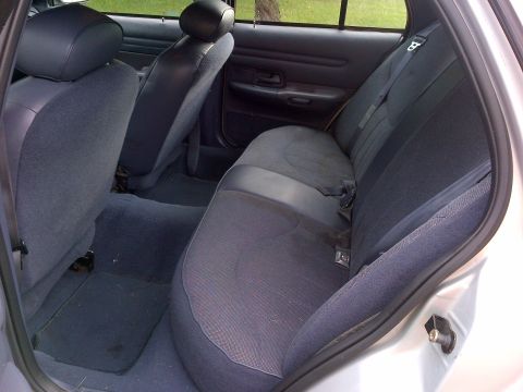 2001 Ford Crown Victoria - Rear interior view of a silver 2001 Ford Crown Victoria, showing the seats and carpeting.