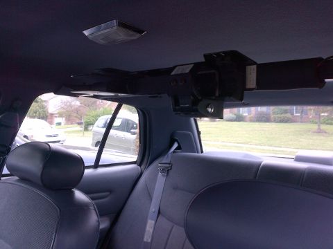 2001 Ford Crown Victoria - Interior view of a 2001 Ford Crown Victoria, showing a device mounted to the headliner above the rear seats.