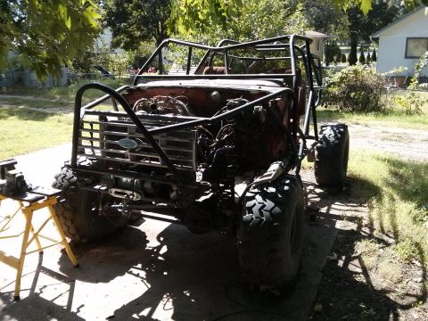 1986 Ford Bronco - This heavily modified vehicle, likely a Ford from the early 1980s, is undergoing extensive off-road customization.