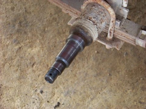1995 Mercury Grand Marquis - A close-up view of a vehicle's spindle and leaf spring assembly, showing signs of rust and wear.
