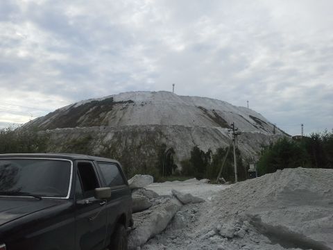 1987 Ford Bronco - 1987 Ford Bronco parked near a large industrial waste pile.