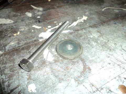 2004 Mercury Grand Marquis - A bolt and washer are shown on a workbench, likely for a vehicle repair or modification.