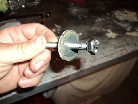 2004 Mercury Grand Marquis - A hand holds a bolt with a washer, likely for a vehicle repair or modification.