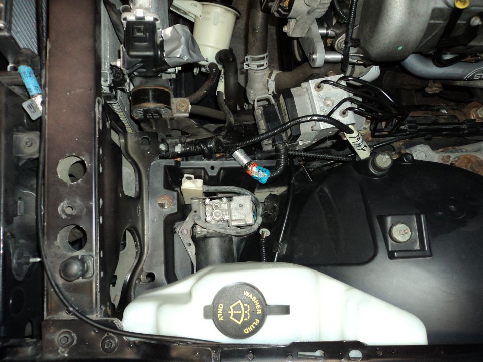 Engine bay with washer fluid reservoir and wiring