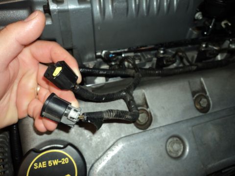 2004 Mercury Grand Marquis - Close-up of engine components and electrical connectors, with an oil cap visible.