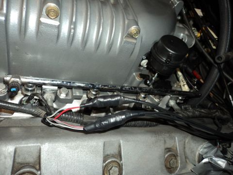 2004 Mercury Grand Marquis - Close-up of engine components, showing a fuel rail and electrical wiring with tape.