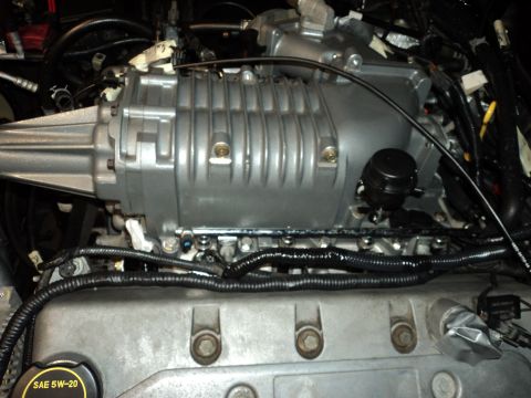 2004 Mercury Grand Marquis - Close-up of a supercharger unit installed on an engine, showing various hoses and wiring.