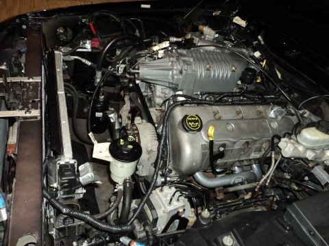 2004 Mercury Grand Marquis - Engine bay features a supercharged V8 motor, radiator, and various engine components.