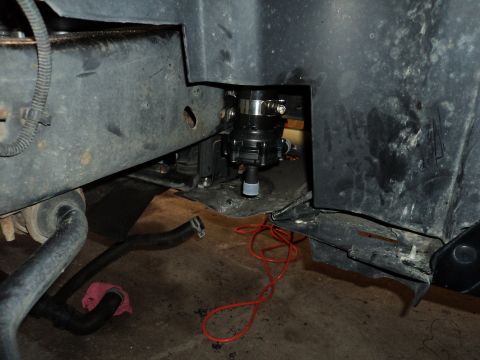 2004 Mercury Grand Marquis - Close-up view of an aftermarket electric water pump installation, showing the pump unit and associated wiring on a vehicle's frame.
