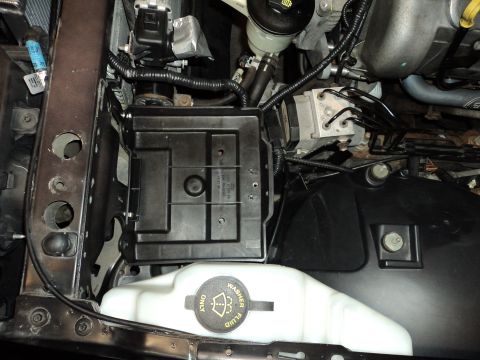 2004 Mercury Grand Marquis - Close-up view of engine bay components including the battery tray and washer fluid reservoir.