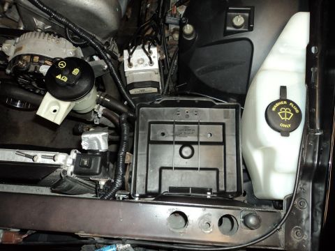 2004 Mercury Grand Marquis - Close-up view of various engine bay components, including reservoirs and the ABS control module.