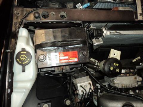2004 Mercury Grand Marquis - Engine bay components including the battery, washer fluid reservoir, and alternator are visible in this image.