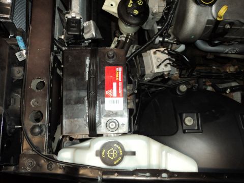 2004 Mercury Grand Marquis - Close-up view of a car's engine bay, focusing on the battery and fluid reservoir.