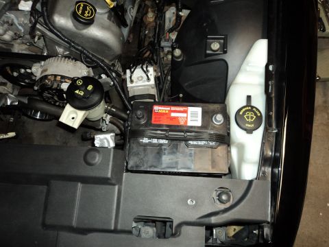 2004 Mercury Grand Marquis - Engine bay of a 2004 Mercury Grand Marquis, the battery and washer fluid reservoir.