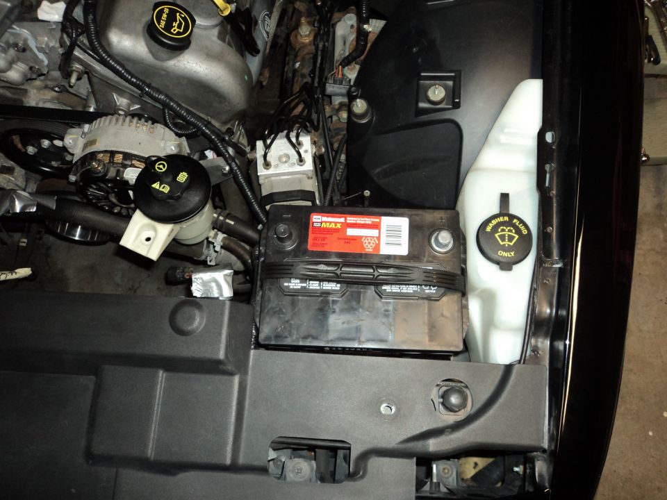 2004 Mercury Grand Marquis engine bay showing battery and washer fluid reservoir
